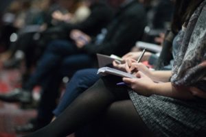 Row of people taking notes