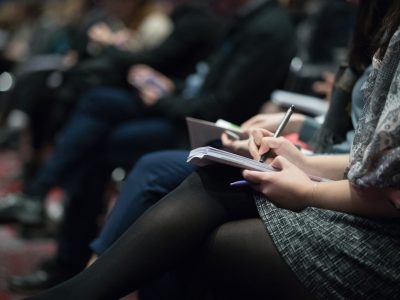 Row of people taking notes